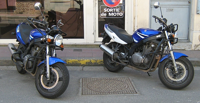 two suzuki gs 500s with crash protection bars on the engine, handlebars and exhaust pipes